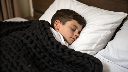 young boy sleeping under knitted weighted blanket